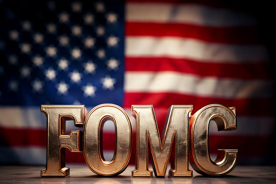 shiny gold FOMC letters with the American flag in the background, representing Federal Open Market Committee meetings